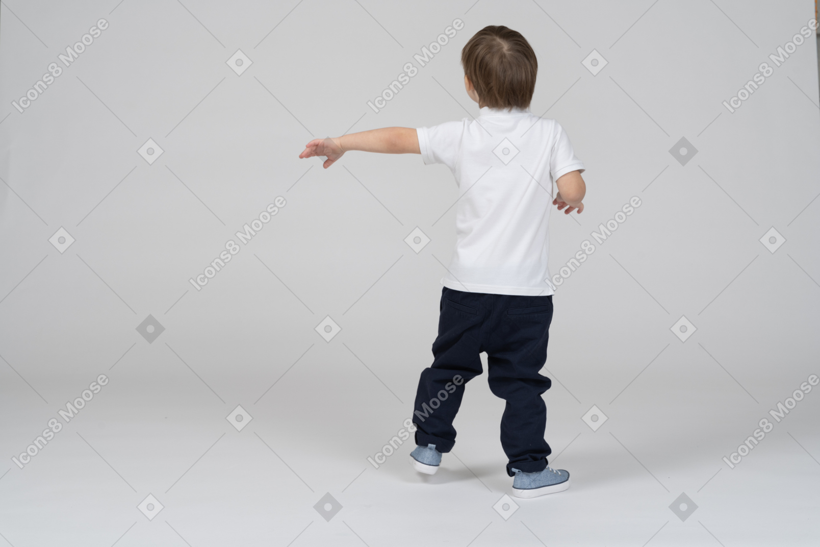 Vista trasera de un niño con una mano hacia la izquierda
