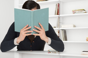 Uomo che legge un libro in biblioteca