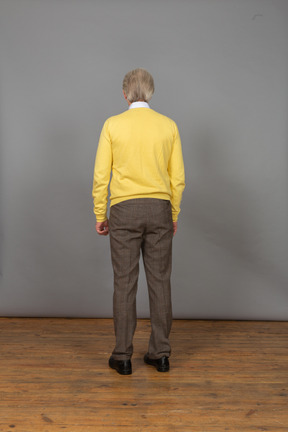 Back view of an old man in a yellow pullover