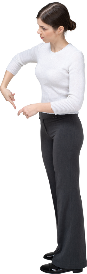 Vista lateral de uma mulher com roupas casuais apontando para baixo com um dedo