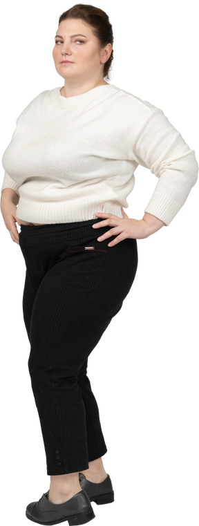 Plump woman in white sweater posing with hands on hips