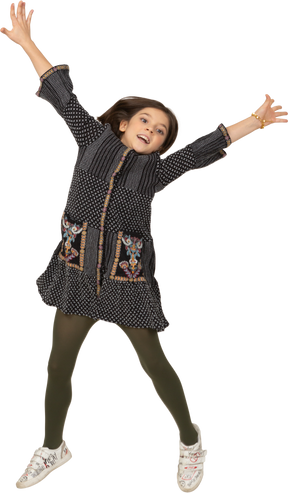 Front view of a jumping little girl in dress outspreading hands and legs