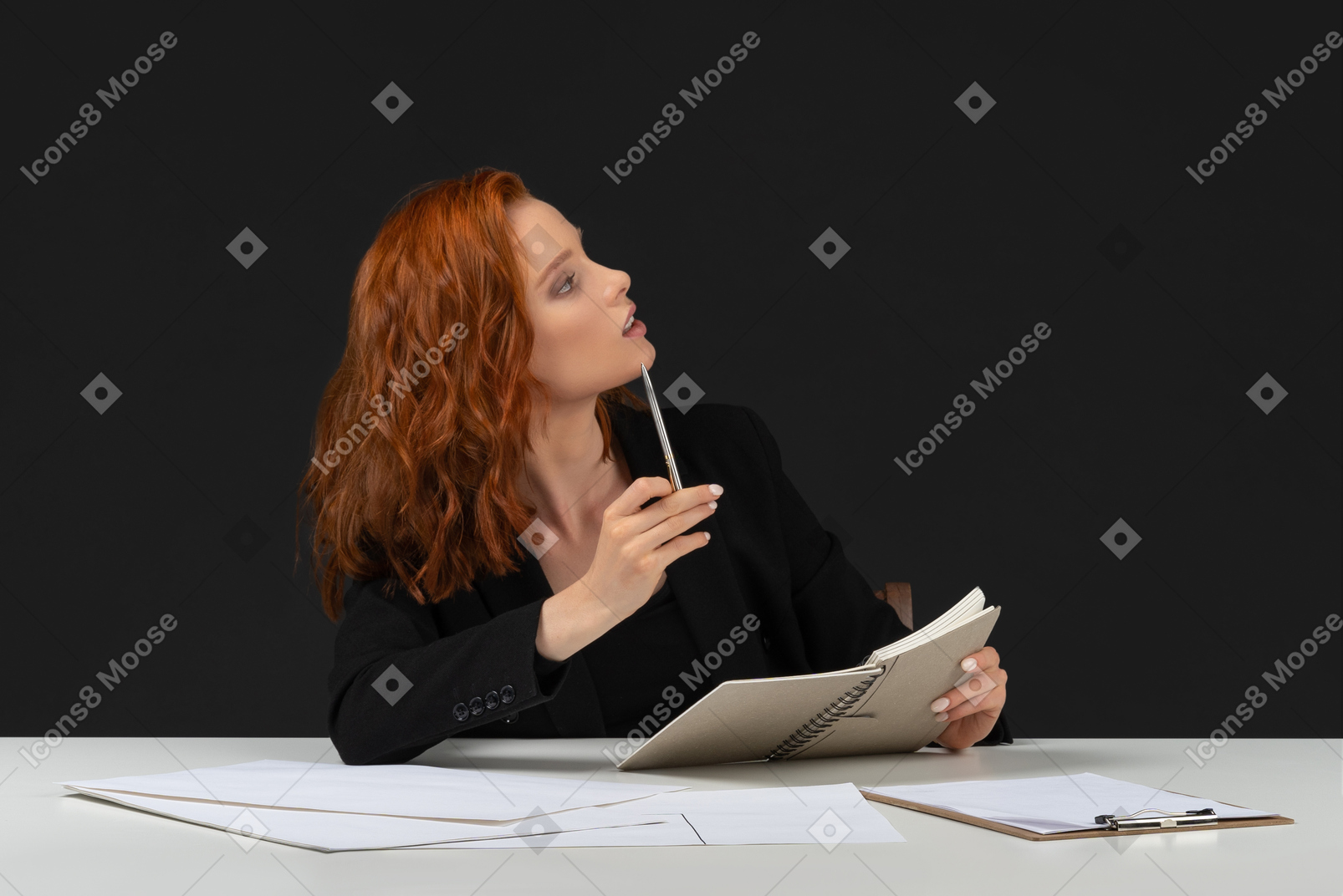Woman with pen and notebook thinking