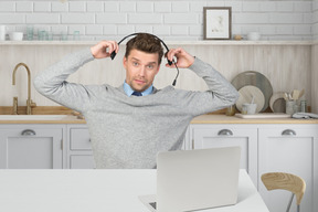 A man with headphones in front of a laptop