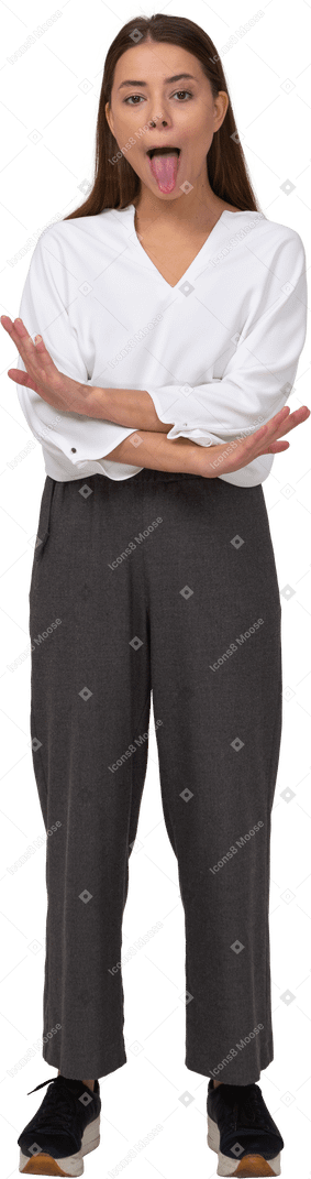 Вид спереди молодой леди в офисной одежде, скрещивающей руки и показывающей язык