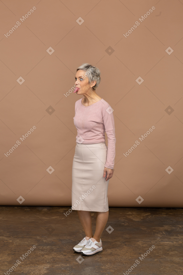 Vista laterale di una donna in abiti casual che mostra la lingua