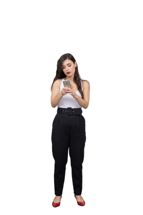 Vista frontal de una mujer joven en ropa de oficina mirando su teléfono