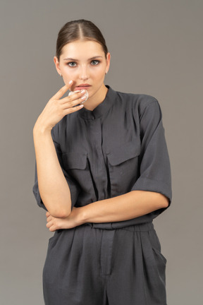 Front view of a young woman in a jumpsuit removing make-up