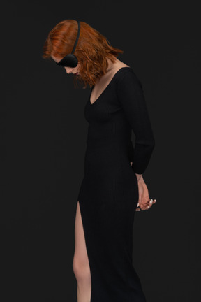 A side view of the cute girl dressed in black and looking down