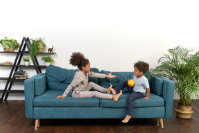 Good looking boy and girl play on the sofa