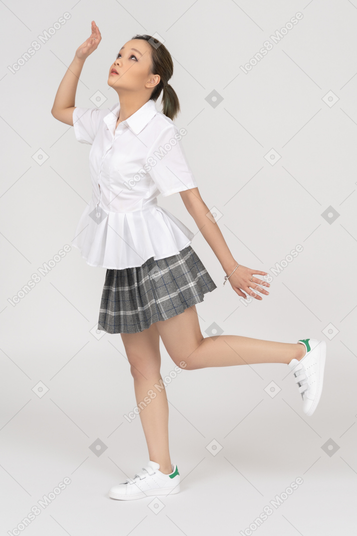 Uma jovem garota asiática tentando tocar algo no ar