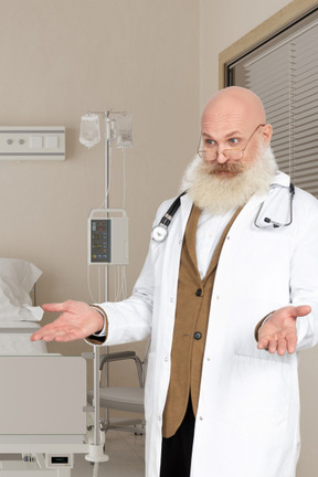 A man in a white lab coat standing next to a bed