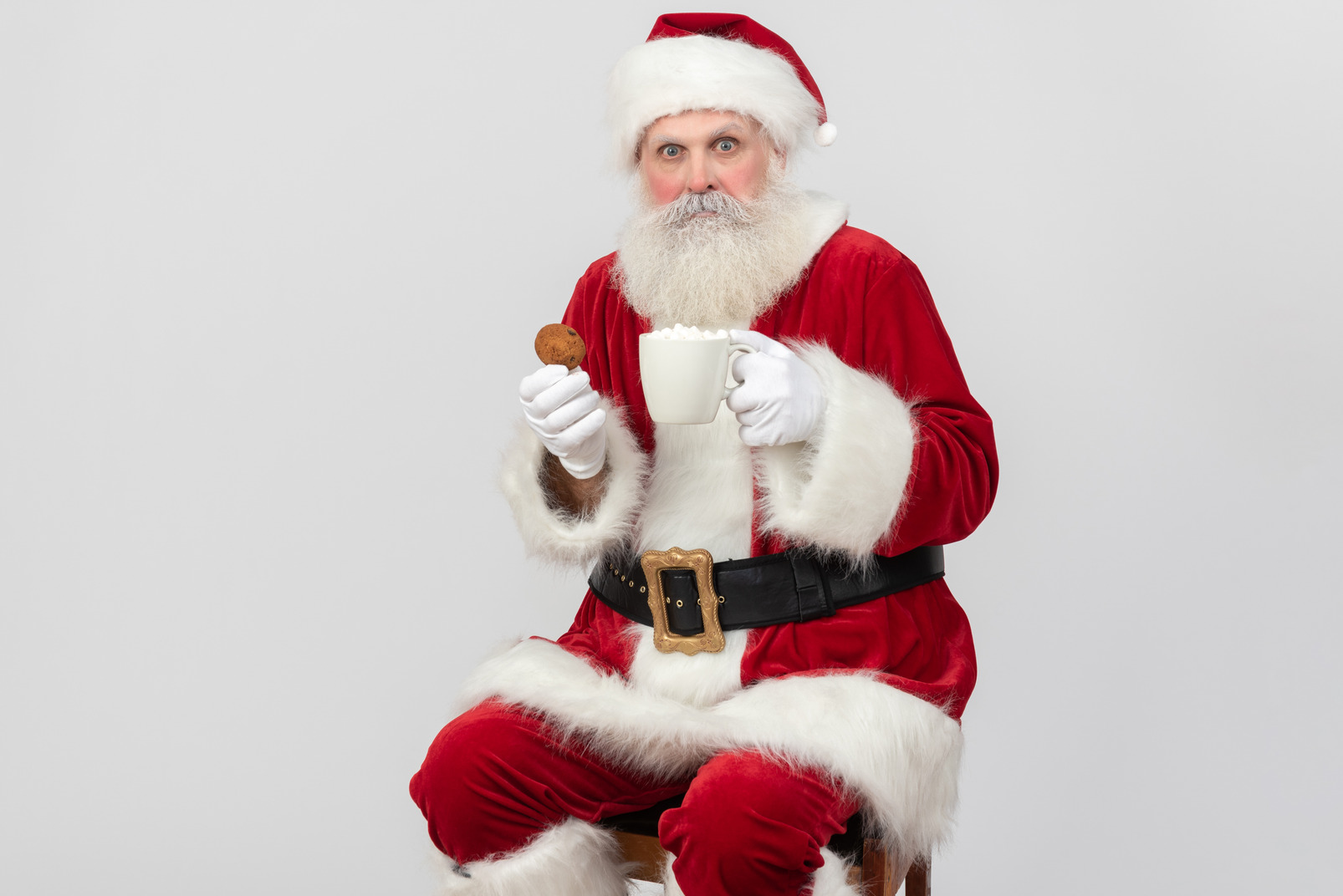 Santa claus holding cup of tea and cookie