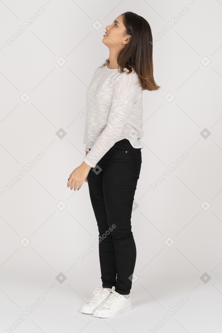 Three-quarter view of a confused young indian female in casual clothes looking up