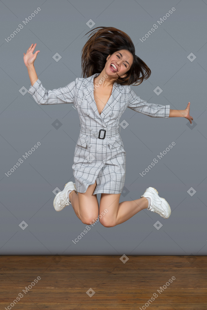 Cheerful young woman jumping high