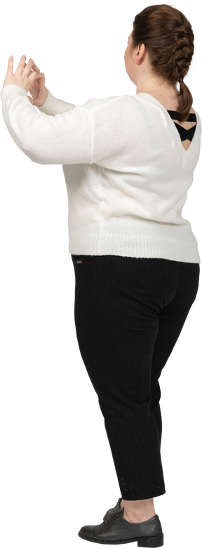Plump woman in white sweater showing heart figure with fingers