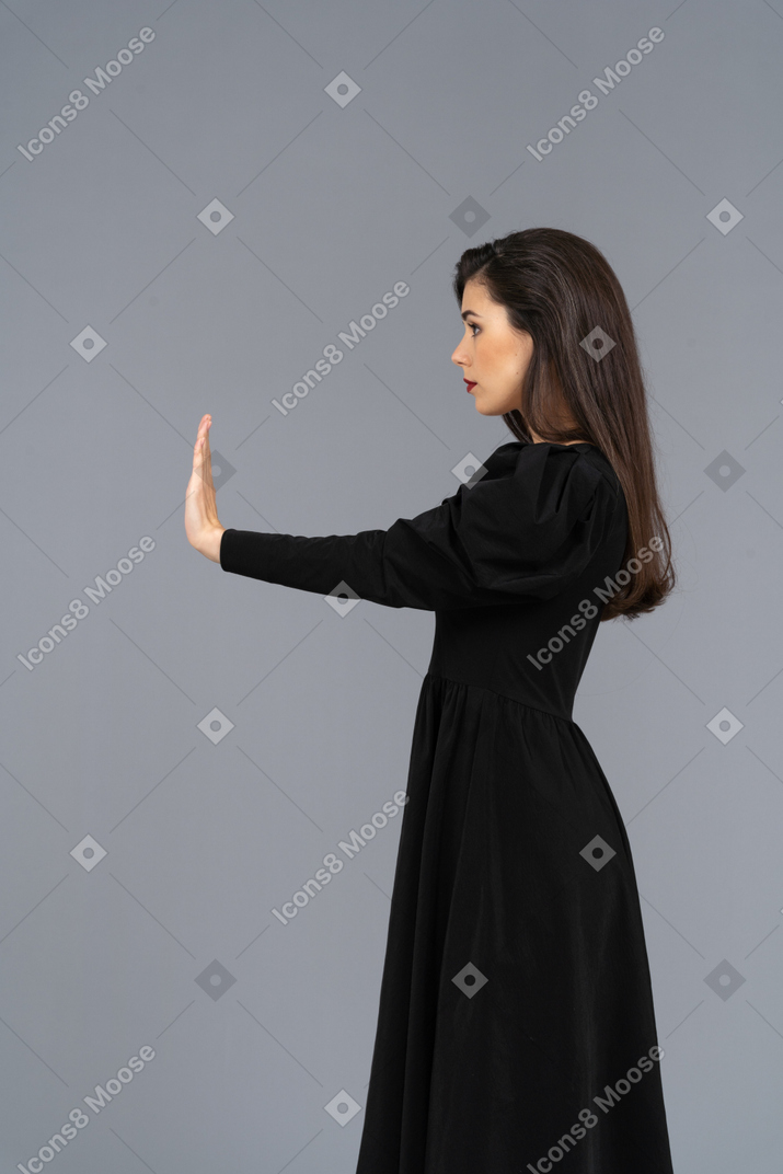 Вид сбоку отвергающей молодой леди в черном платье