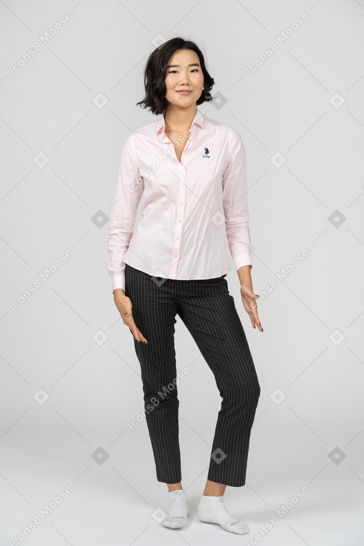 Счастливая женщина в офисной одежде позирует с руками по бокам
