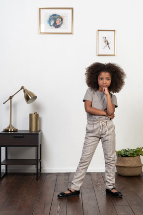 Good looking girl kid posing on the apartment background