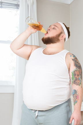 A man with a beard drinking from a bottle