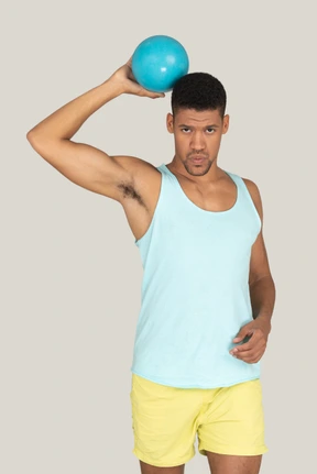 Sporty man holding a blue ball up