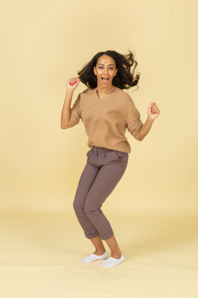 Front view of a dark-skinned walking young female