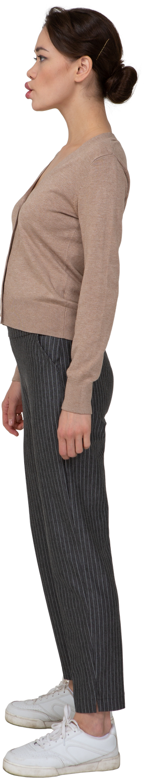 Vue latérale d'une dame boudeuse en pull et pantalon à la recherche de côté