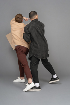 Back view of two young men with a billboard looking over their shoulders in panic