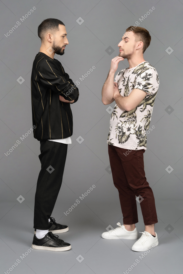 Side view of two young men looking troubled