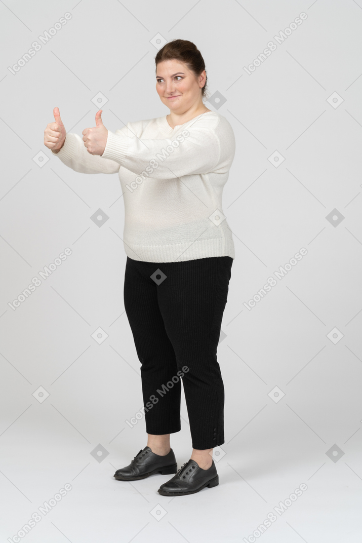 Happy plus size woman in casual clothes showing thumbs up