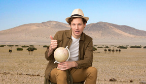A traveller holding a globe and giving a thumbs up