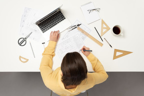 A female architect working on architectural drawings