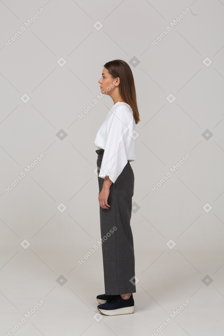 Vista lateral de una joven en ropa de oficina mirando a un lado