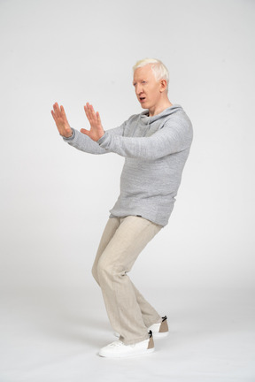 Side view of man showing stop gesture with two hands