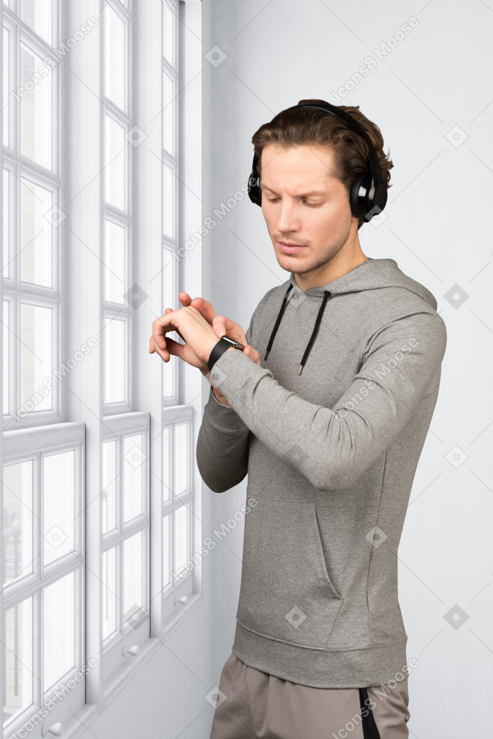 戴耳机的男人检查他的手表