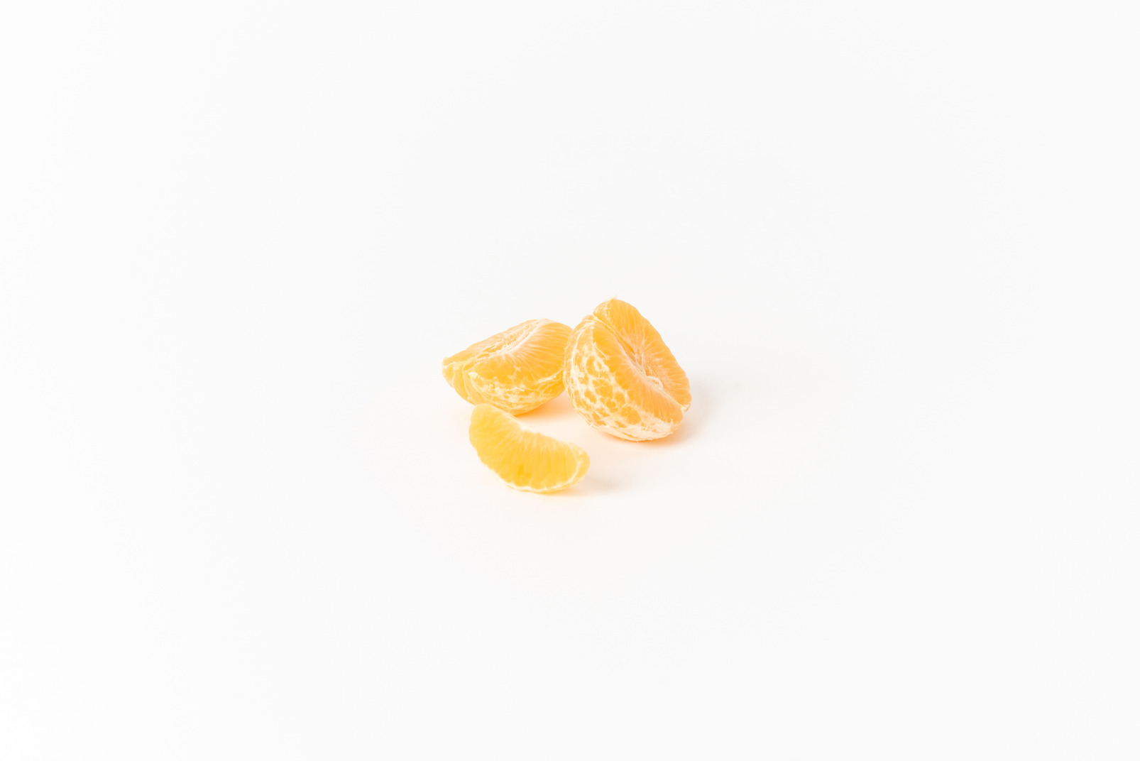 Peeled mandarin segments on a white background
