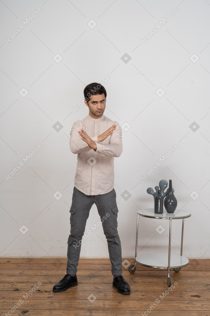 一个穿着休闲服的男人的前视图显示停止手势