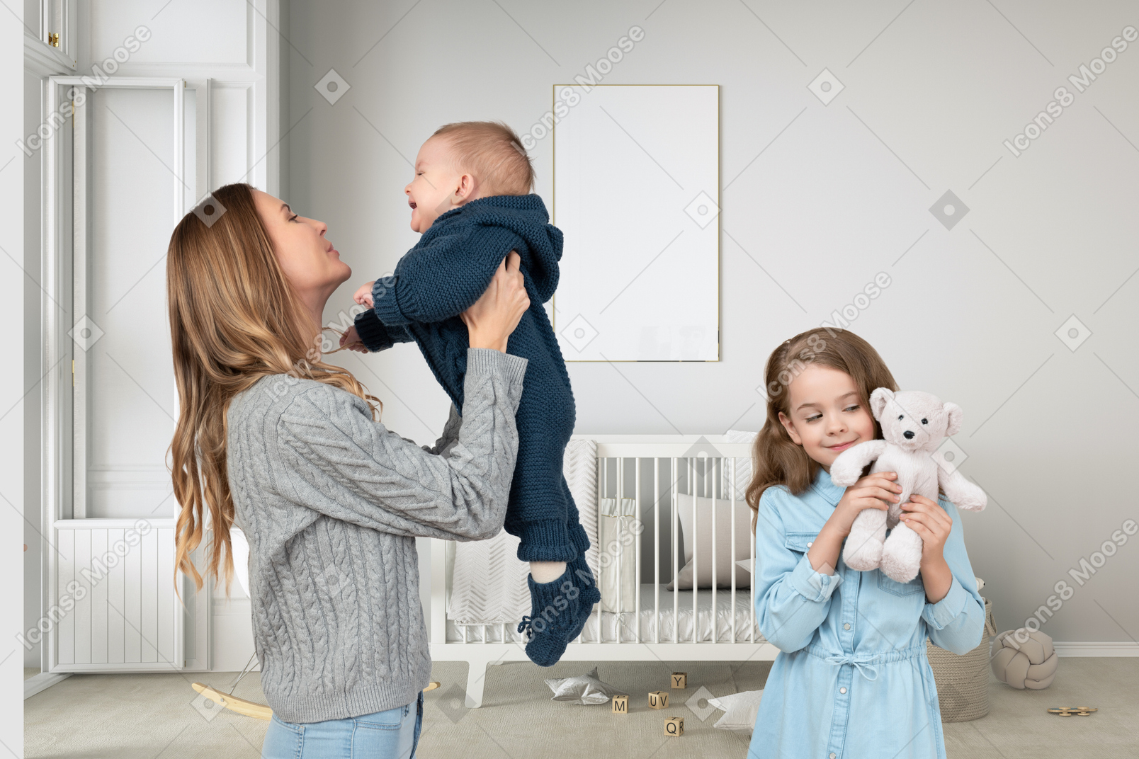 Woman holding a baby up next to little girl