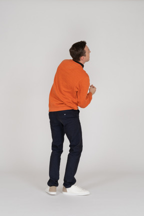 Junger mann im orangefarbenen sweatshirt tanzen