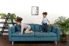 Good looking boy and girl play on the sofa