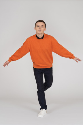 Junger mann im orange sweatshirt posiert