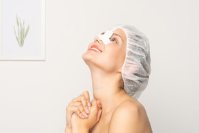 Smiling young woman with bandaged nose looking up