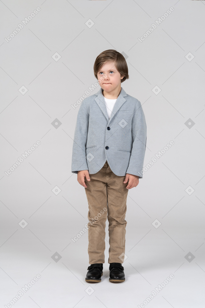 A young boy wearing a gray jacket and khaki pants
