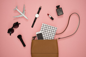 Female bag and accessories on a pink background