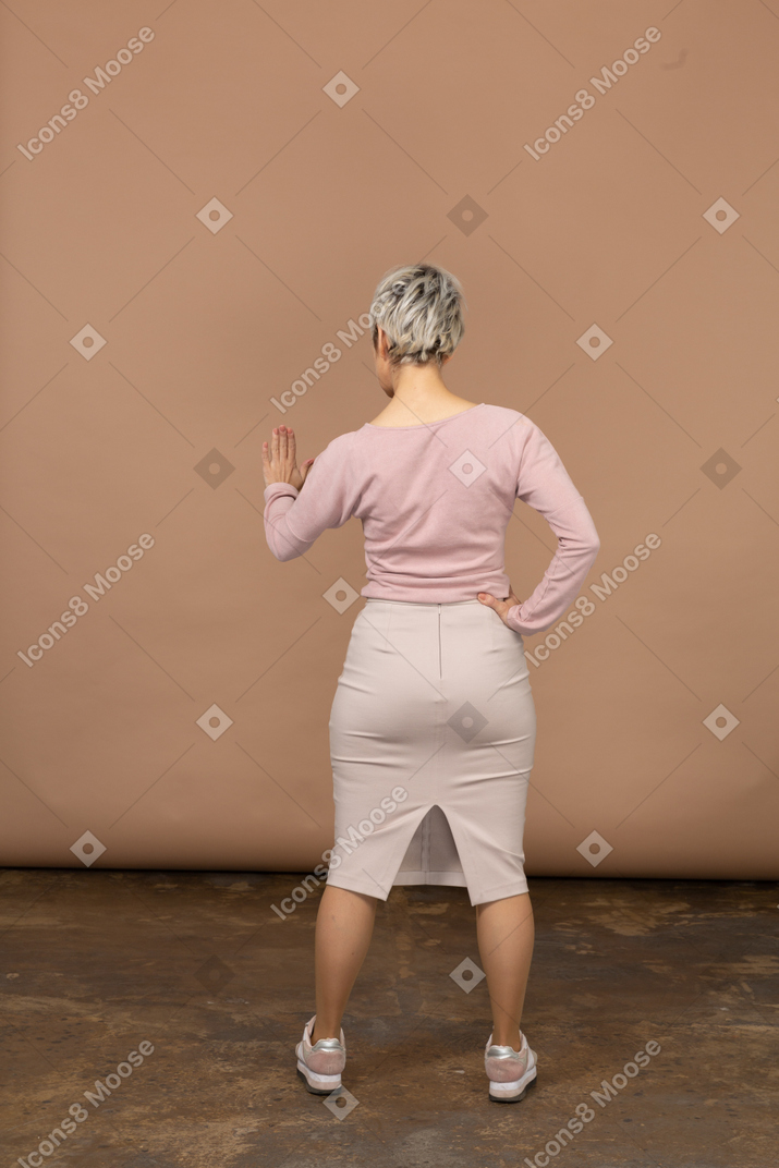 一个穿着休闲服的女人的后视图，显示停止手势