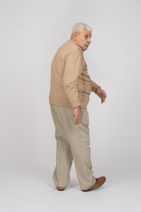 Vue arrière d'un vieil homme en tenue décontractée marchant