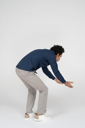一个穿着休闲服的男人弯下腰的侧视图