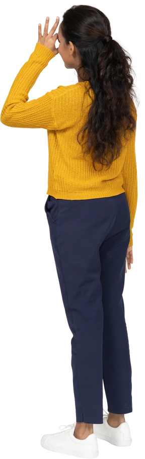 Rear view of a girl in casual clothes looking through fingers