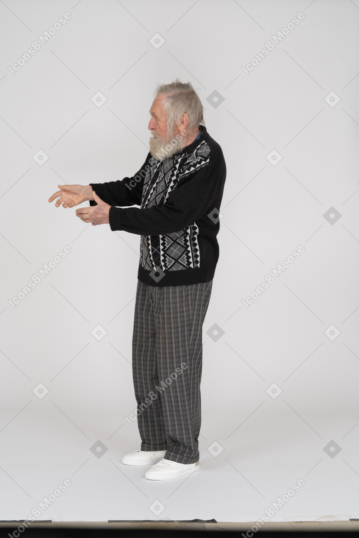 Side view of an old man gesturing to the left