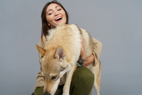 미소하고 그녀의 강아지를 껴안은 여성 마스터의 근접